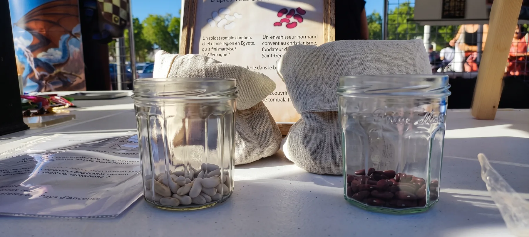 Deux bocaux, haricots blancs et haricots rouges, devant l'énigme encadrée : d'après vous, qui était Géréon ?