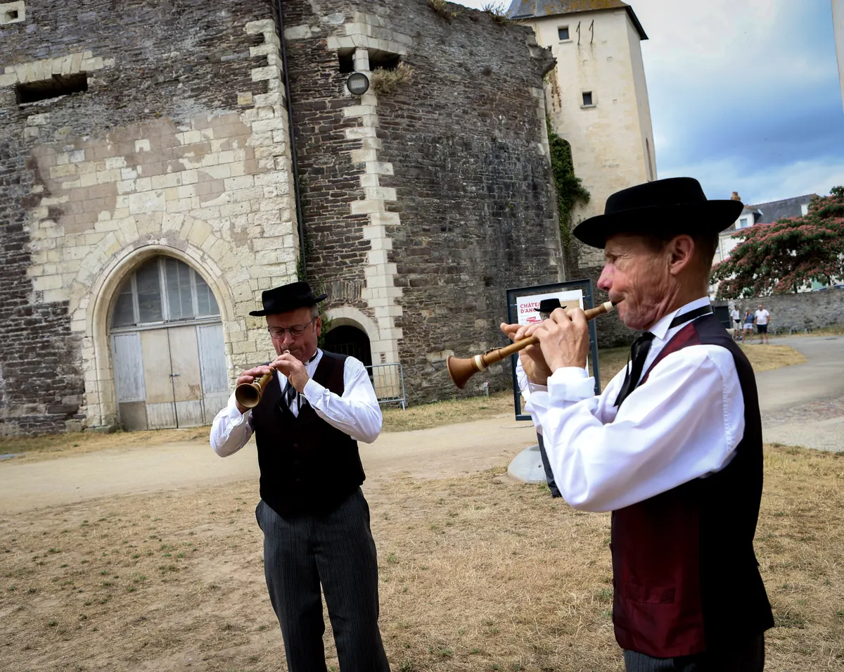 Deux sonneurs en costume dans la cour du château